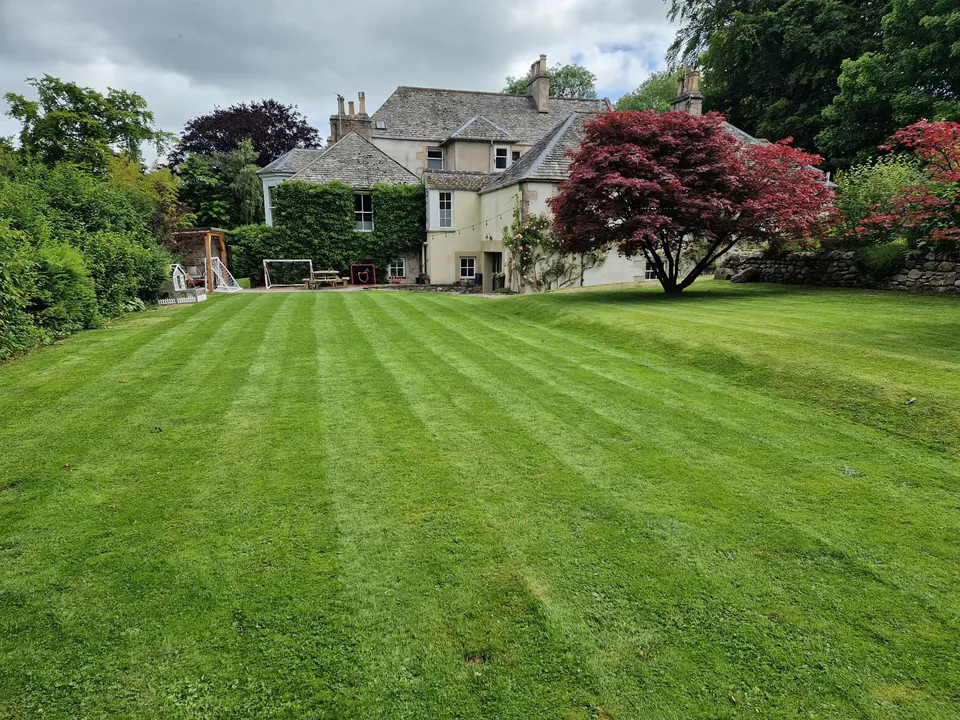 Broad lawn maintained in front of a country hotel